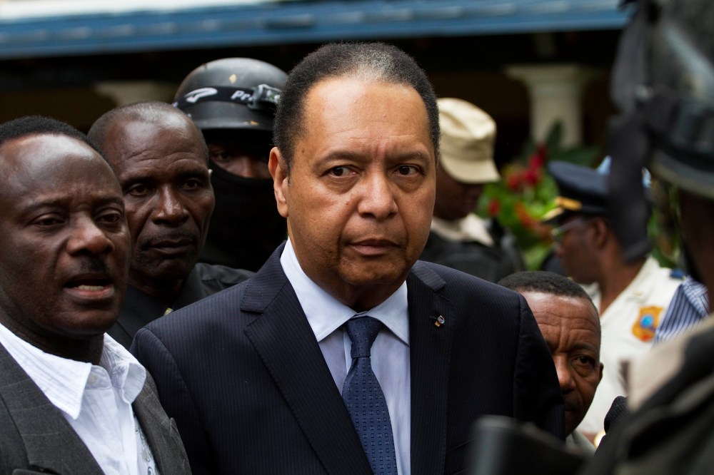 Haiti's ex-dictator Jean-Claude Duvalier is escorted out of his hotel in Port-au-Prince, Haiti Jan. 18, 2011. (Photo by Ramon Espinosa/AP)