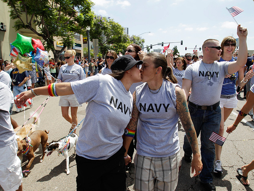 In this July 16,2011 photo, two women, both active duty sailors in the Navy who gave their names as Nikki, left, and Lisa, kiss as they march in the Gay Pride Parade in San Diego. (Photo by Gregory Bull/AP)