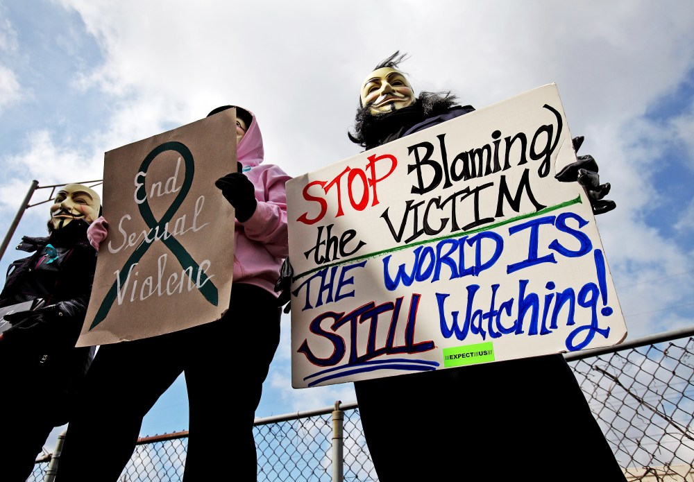 Protesters hold signs outside of the Jefferson County Justice Center and Jail in Steubenville, Ohio, on Wednesday, March 13, 2013.