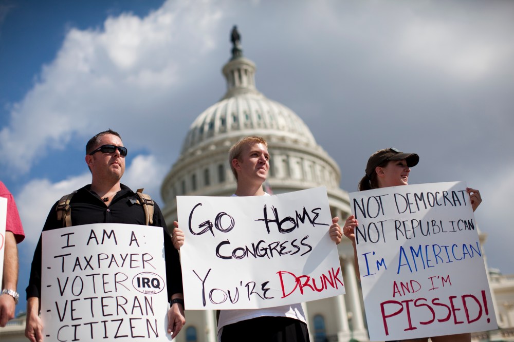 Protestors holds signs against the government shutdown on the West Front of the U.S. Capitol building on Capitol Hill on Friday, Oct. 4, 2013 in Washington.
