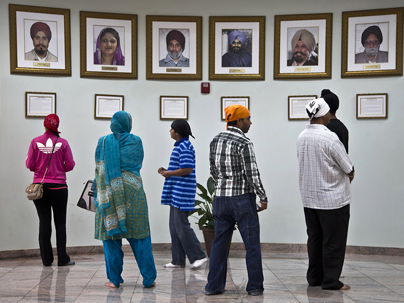 Visitors look at a memorial near the entrance of the Sikh Temple of Wisconsin Wednesday, July 31, 2013, in Oak Creek, Wis. Twelve months ago a white supremacist shot and killed six temple members, and the survivors plan to mark the one-year anniversary...