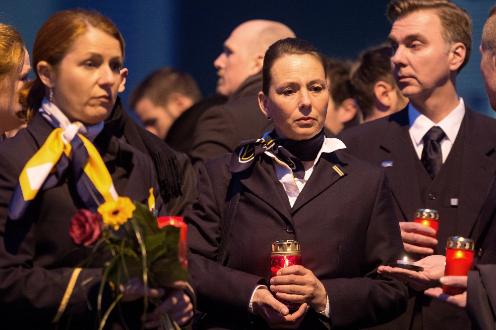 Staff members of Germanwings and Lufthansa stand in front of the headquarter of air carrier Germanwings placing flowers and candles at the main entrance in Cologne, Germany, March 24, 2015. (Photo by Marius Becker/picture-alliance/dpa/AP)