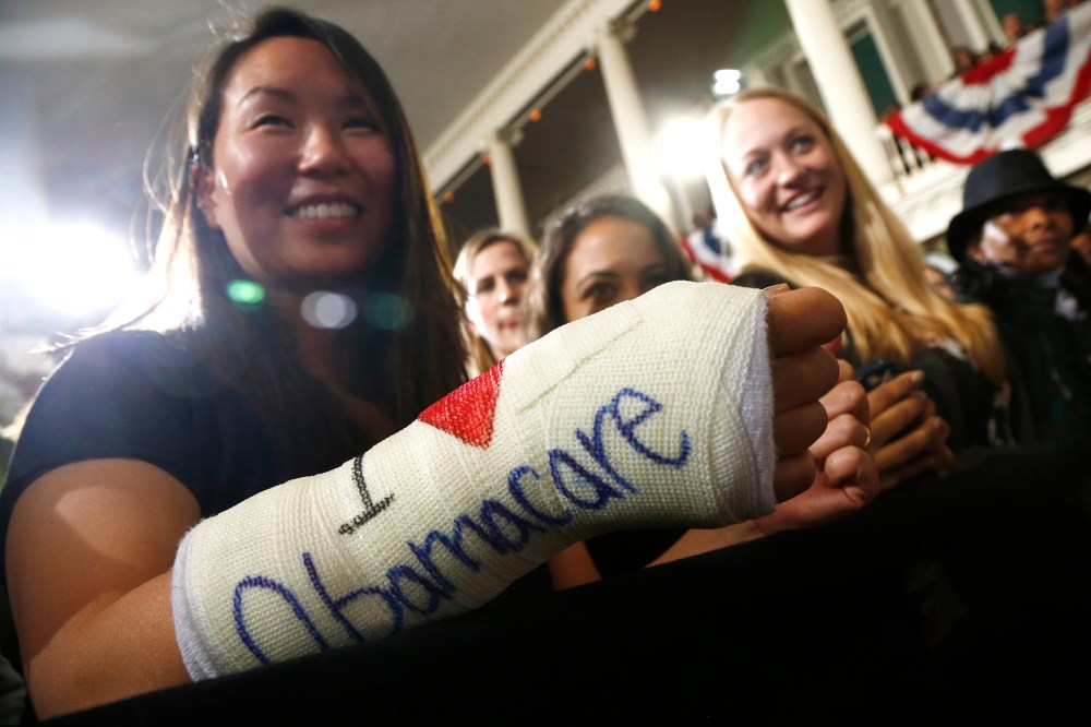 Cathey Park from Cambridge, Mass. shows the words "I Love Obamacare" on her cast for her broken wrist Faneuil Hall in Boston on Oct. 30, 2013.