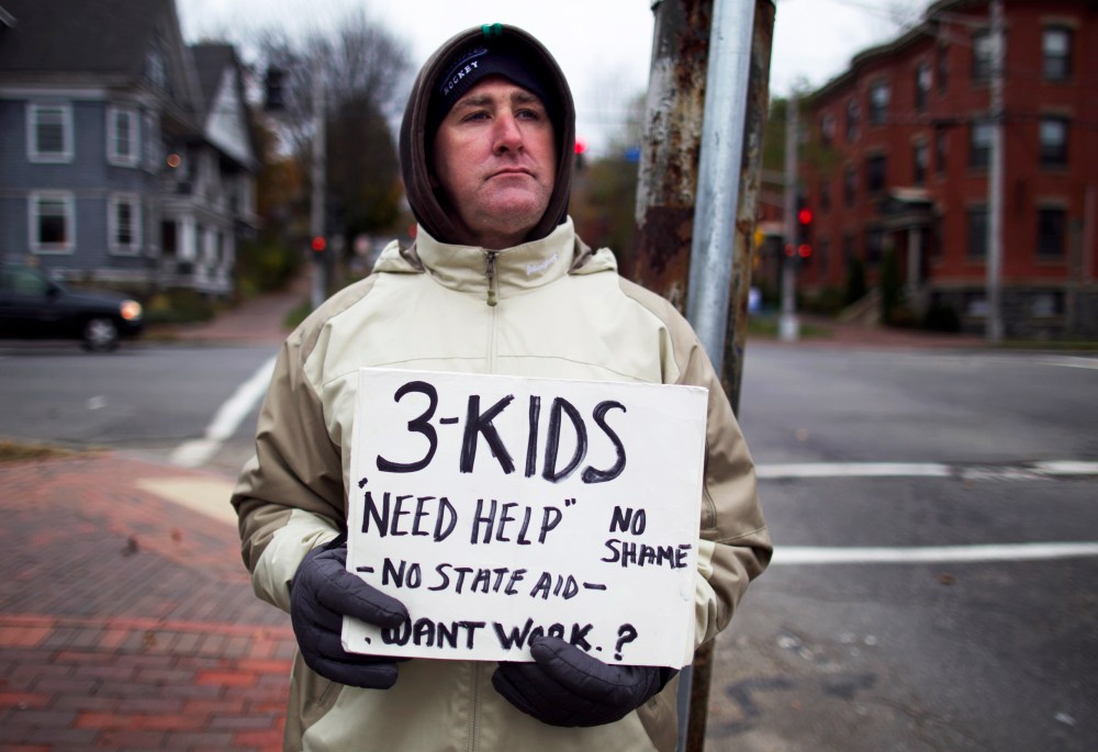 Brian Adams, 42, stands on the corner of State Street and Park Avenue, in Portland, Maine, Wednesday, Nov. 7, 2012. Adams, who lives with his fiance and their three children on Munjoy Hill, lost his job as a mason.