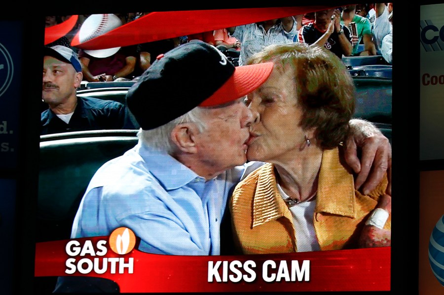 Former President Jimmy Carter kisses his wife, Rosalynn, on the 