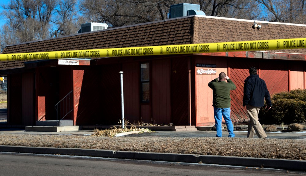 Colorado Springs police officers investigate the scene of an explosion on Jan. 6, 2015, at a building in Colorado, which houses a barber shop and the Colorado Springs chapter of the NAACP. (AP Photo/The Colorado Springs Gazette, Christian Murdock)