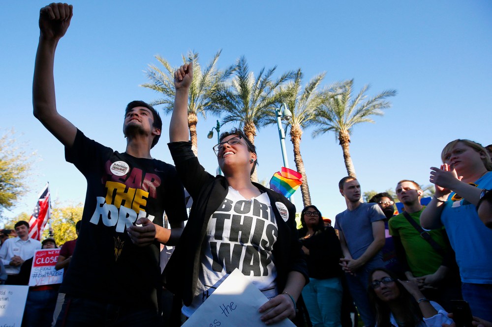 Anthony Musa, left, and Brianna Pantillione join nearly 250 gay rights supporters protesting SB1062 at the Arizona Capitol, Friday, Feb. 21, 2014, in Phoenix.