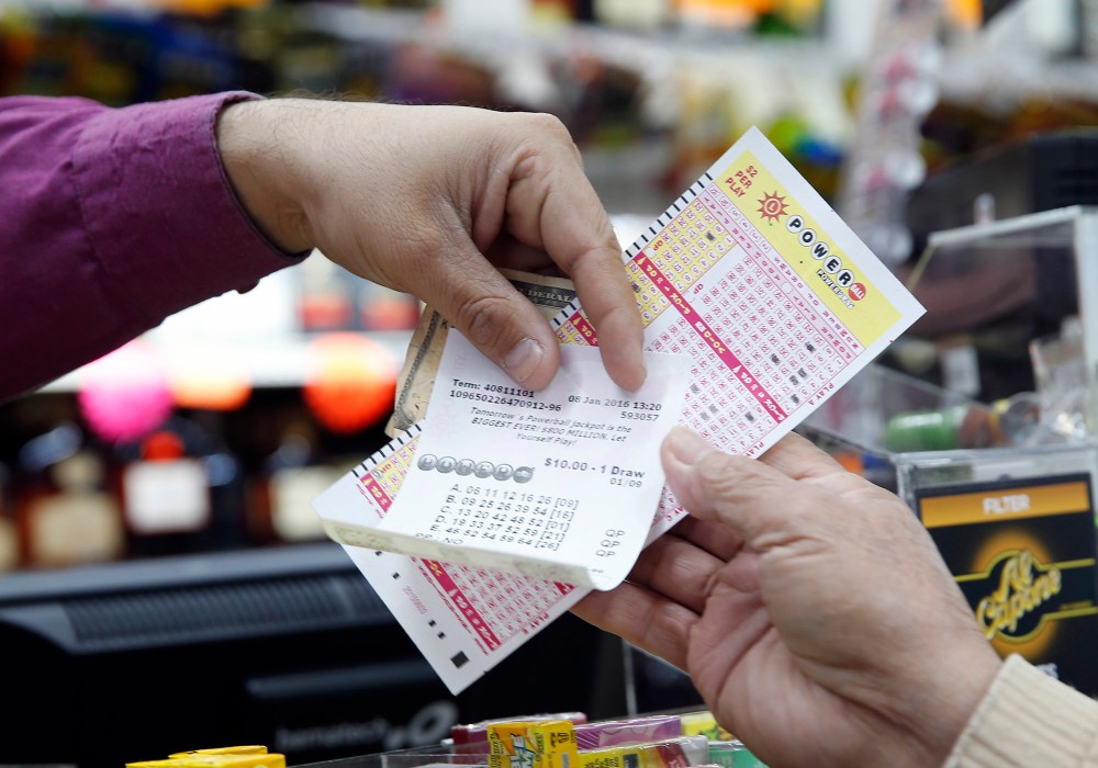 Money and Powerball tickets change hands at Pine Liquors in Fort Washington, Md., Jan. 8, 2016, for the upcoming Powerball drawing. (Photo by Alex Brandon/AP)