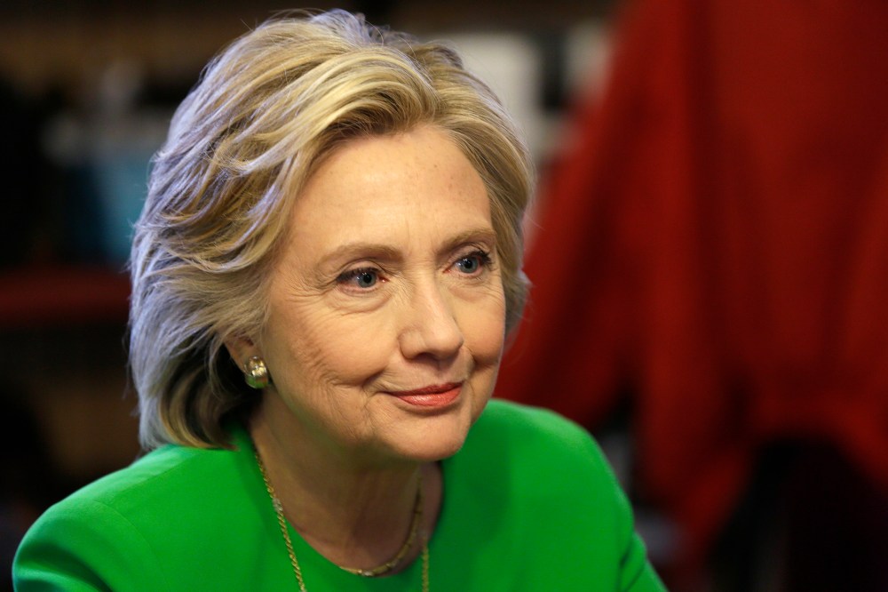 In this April 14, 2015, photo, Democratic presidential candidate Hillary Rodham Clinton meets with local residents at the Jones St. Java House in LeClaire, Iowa. (Photo by Charlie Neibergall/AP)