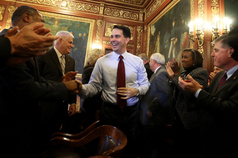 Wisconsin Republican Gov. Scott Walker is greeted by members of his staff and cabinet at the Wisconsin State Capitol building in Madison, Wis., Nov. 5, 2014. (Photo by John Hart/Wisconsin State Journal/AP)