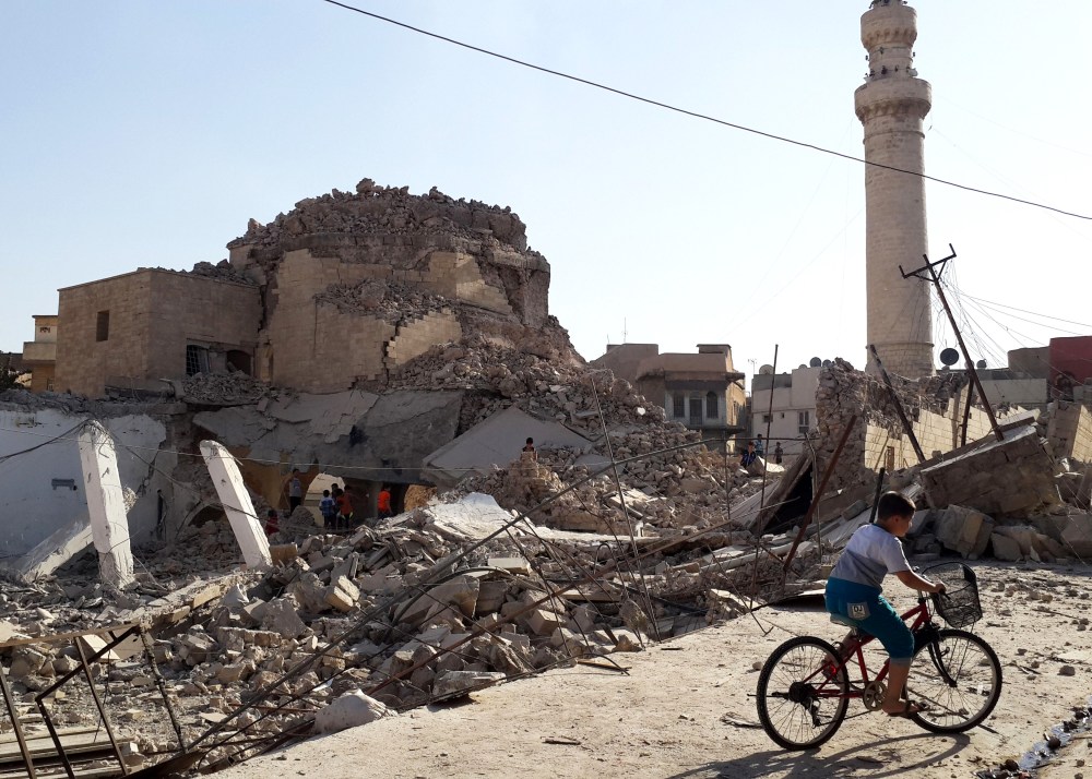 A bicyclist rides by the remnants of the old Mosque of The Prophet Jirjis, destroyed by Islamic State militants, in central Mosul, Iraq, on July 27, 2014. (File Photo/AP)