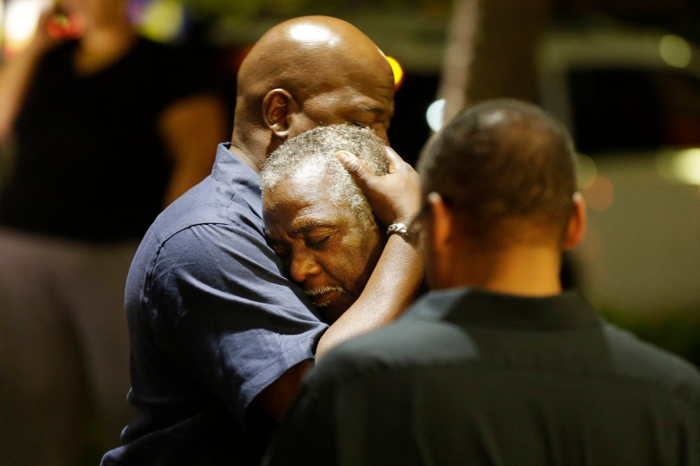 Worshippers embrace following a group prayer across the street from the scene of a shooting, June 17, 2015, in Charleston, S.C. (Photo by David Goldman/AP)