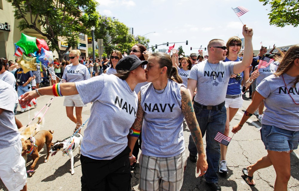 Two women, both active duty sailors in the Navy, kiss as they march in a Gay Pride Parade in San Diego.