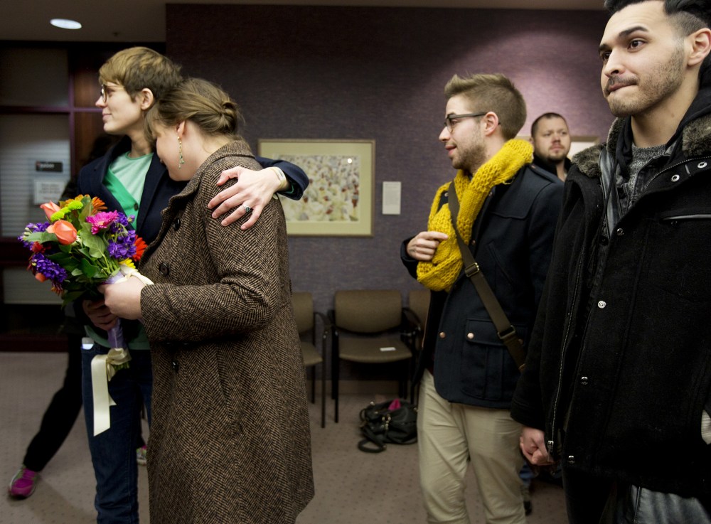 Same-sex couples Natalie Dicou, left, and Nichole Christensen, middle left, and James Goodman, middle right, and Jeffrey Gomez, right, wait in line to get a marriage license at the Salt Lake County Clerk's Office in Salt Lake City, Dec. 20, 2013.
