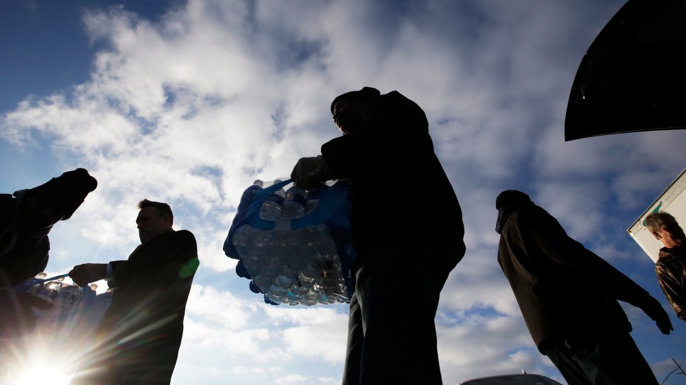 Midwest Food Bank workers and volunteers carry cases of donated water, Jan. 27, 2016, in Indianapolis. All of the water that was collected will be sent to Flint, Mich., where drinking water has been contaminated by lead. (Photo by Darron Cummings/AP)