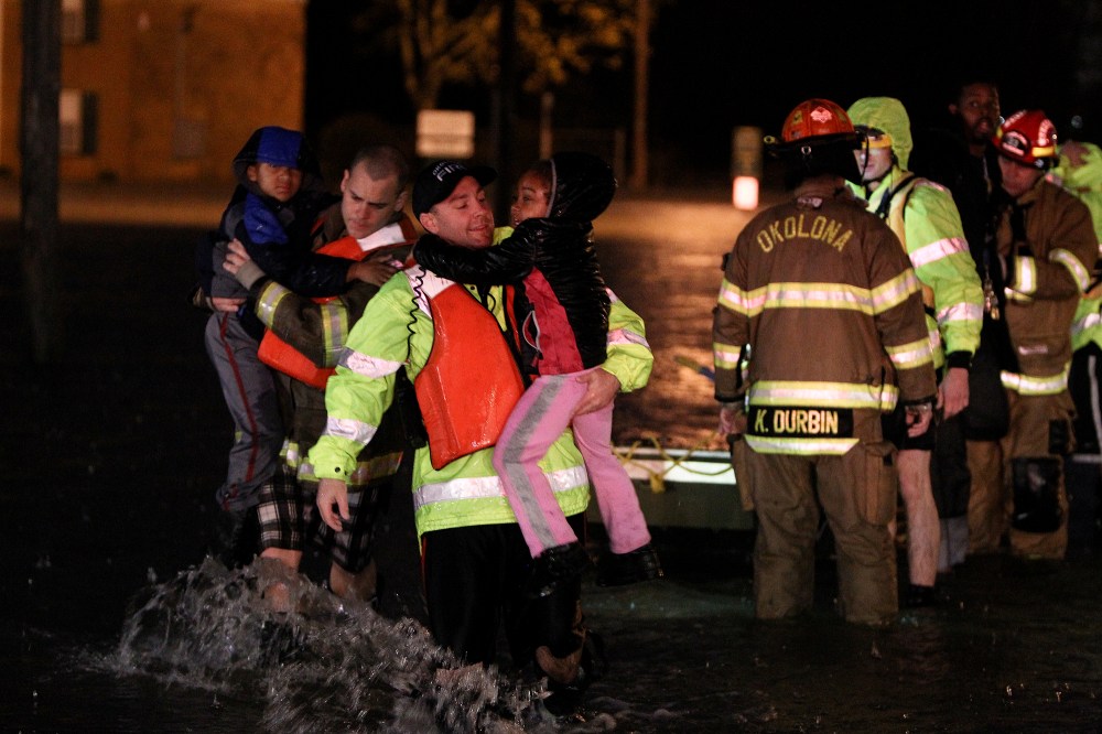 Rescue crews help residents at the Guardian Court Apartments evacuate after flooding in the area on April 3, 2015 in Louisville, Ky. (Photo by Michael Clevenger/The Courier-Journal via AP)