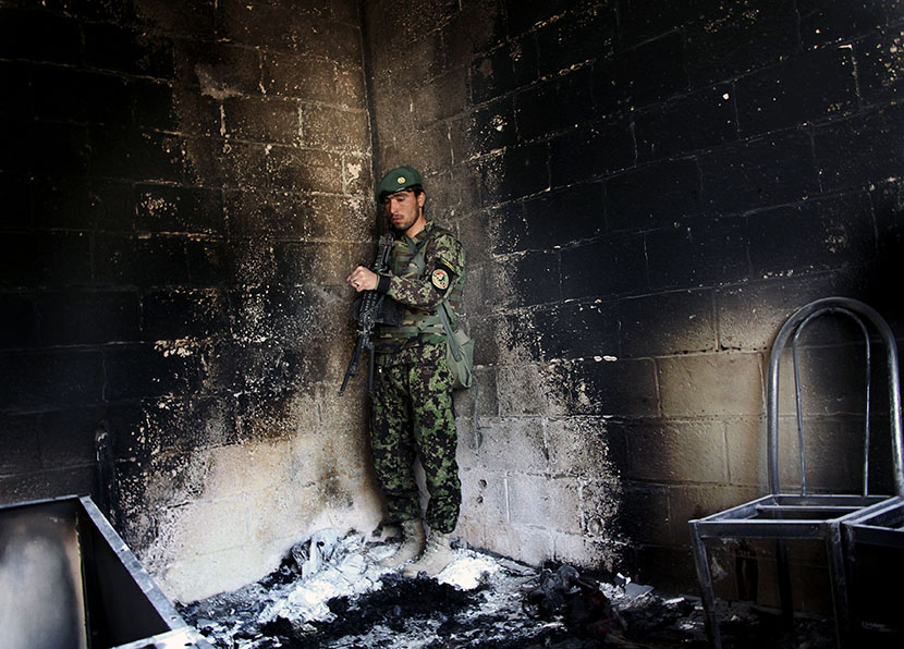 An Afghan army soldier stands guard in the destroyed courthouse in Farah, western Afghanistan, Thursday, April 4, 2013. Suicide bombers disguised as Afghan soldiers stormed a courthouse Wednesday in a failed bid to free more than a dozen Taliban...