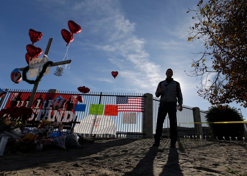 A man pays his respects at a makeshift memorial, Dec. 5, 2015, in San Bernardino, Calif. (Photo by Chris Carlson/AP)