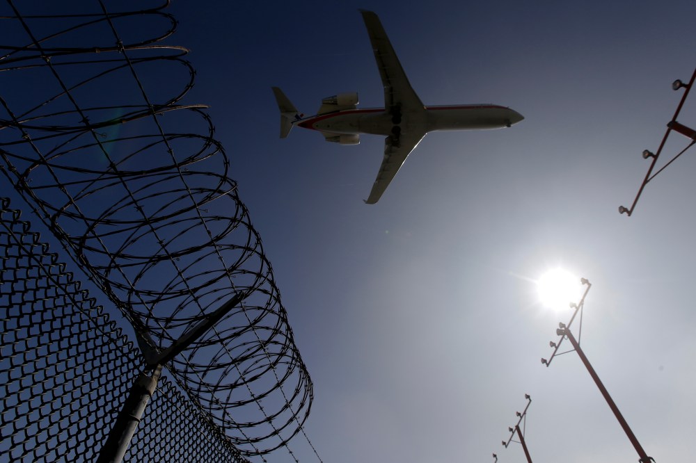 In this Feb. 6, 2015 photo, a passenger jet flies over the perimeter fence at the Los Angeles International Airport as it lands. (Photo by Chris Carlson/AP)