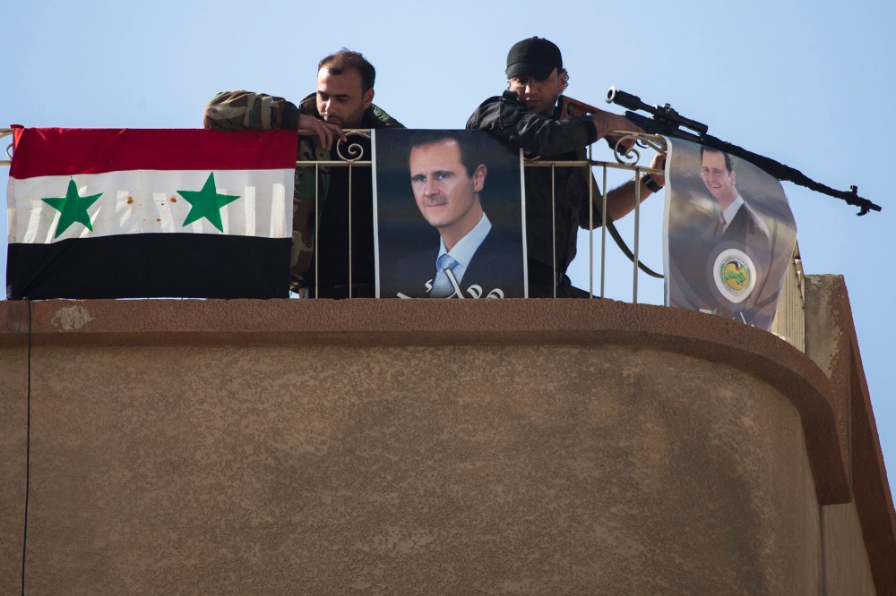 Syrian solders keep watch on a roof with portraits of Syrian President Bashar Assad in Al-Tall, a town of northern outskirts of Damascus, Syria, March 3, 2016. (Photo by Pavel Golovkin/AP)
