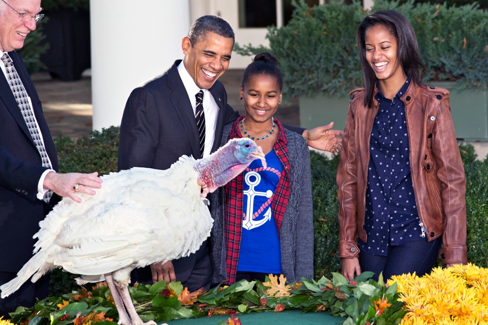 President Barack Obama, with daughters Sasha, center, and Malia, right, carries on the "presidential pardon" tradition at the White House in Washington, D.C., Nov. 21, 2012. (Photo by J. Scott Applewhite/AP)