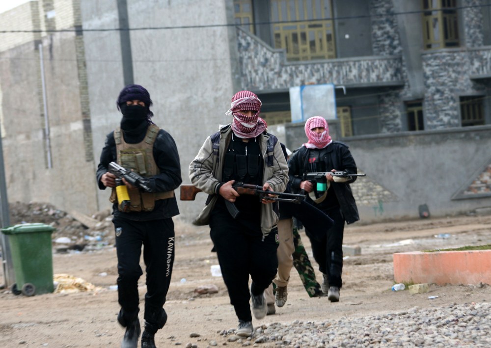 Gunmen patrol during clashes with Iraqi security forces in Fallujah, 40 miles west of Baghdad, Iraq, Jan. 5, 2014.