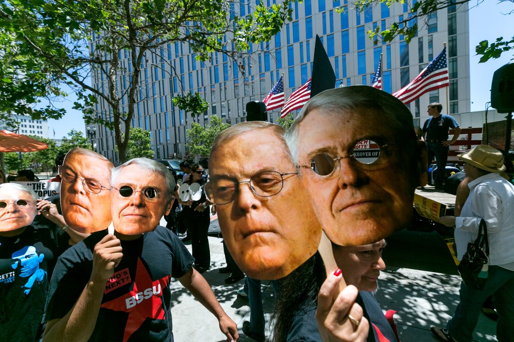 Members of the "Save Our News'' coalition protest with images of billionaire brothers Charles and Bill Koch in Los Angeles Wednesday, May 29, 2013.