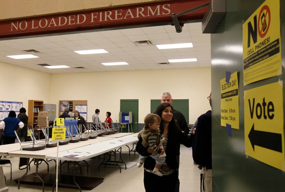 Melissa McBrien and son Tyler, 11 months, exit a polling precinct after voting at the Wake County Firearms Education and Training Center on Election Day in Apex, N.C., Tuesday, Nov. 6, 2012. (AP Photo/Gerry Broome)