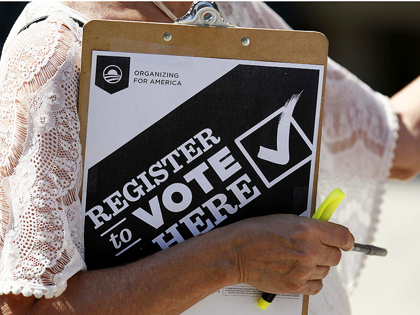 In this photo taken Wednesday, Sept. 26, 2012, a campaign volunteer attemps to register voters in downtown Raleigh, N.C. (Photo by Gerry Broome/AP)
