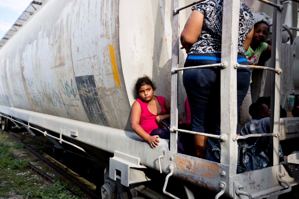 A young migrant girl waits for a freight train to depart on her way to the U.S. border, in Ixtepec, Mexico, July 12, 2014.