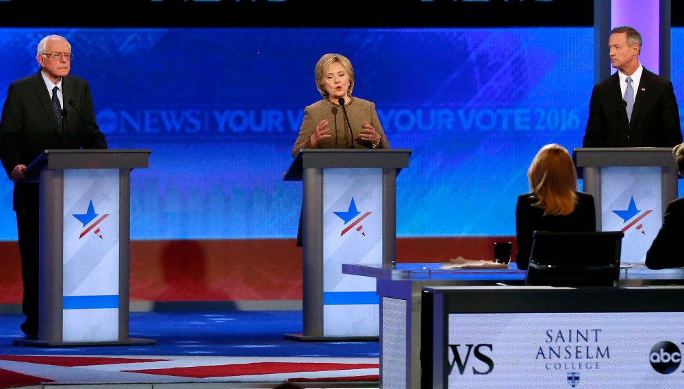 Hillary Clinton, center, speaks between Bernie Sanders and Martin O'Malley during a Democratic presidential primary debate, Dec. 19, 2015, at Saint Anselm College in Manchester, N.H. (Photo by Jim Cole/AP)