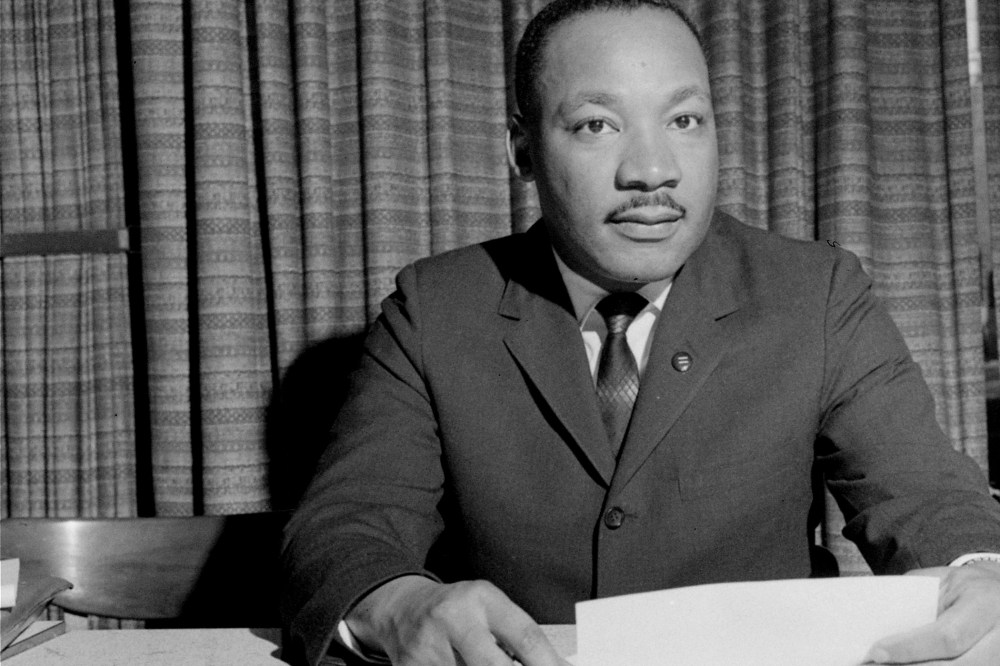 Dr. Martin Luther King, Jr. is shown discussing a forthcoming speech, March 18, 1964, from his home in Atlanta, Ga. (Photo by AP)