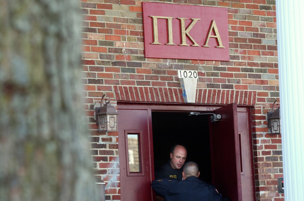 DeKalb and Northern Illinois University police speak in the doorway of the Pi Kappa Alpha house in DeKalb, Ill. where police were investigating the death of NIU freshman David Bogenberger, Nov. 2, 2012. (Photo by Kyle Bursaw/Daily Chronicle/AP)