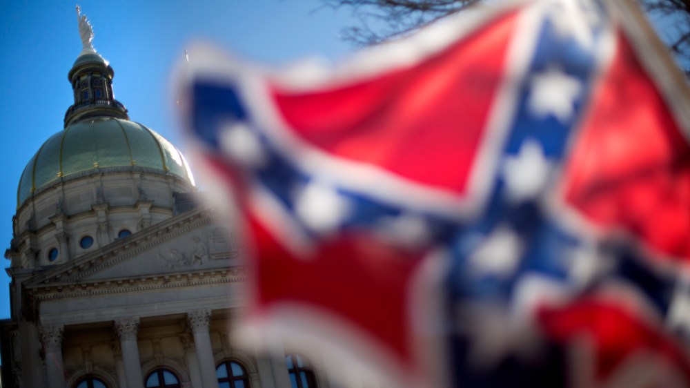 The dome of the State Capitol is seen as a protestor waves a Confederate flag during the March For Life anti-abortion rally, Jan. 22, 2014, in Atlanta, Ga. (Photo by David Goldman/AP)