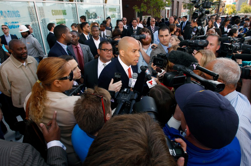 Democratic Newark Mayor and senate candidate Cory Booker, center, is surrounded by media as he answers questions in Newark, N.J. on Wednesday, Sept. 25, 2013, after a ribbon-cutting ceremony for Newark charter schools.
