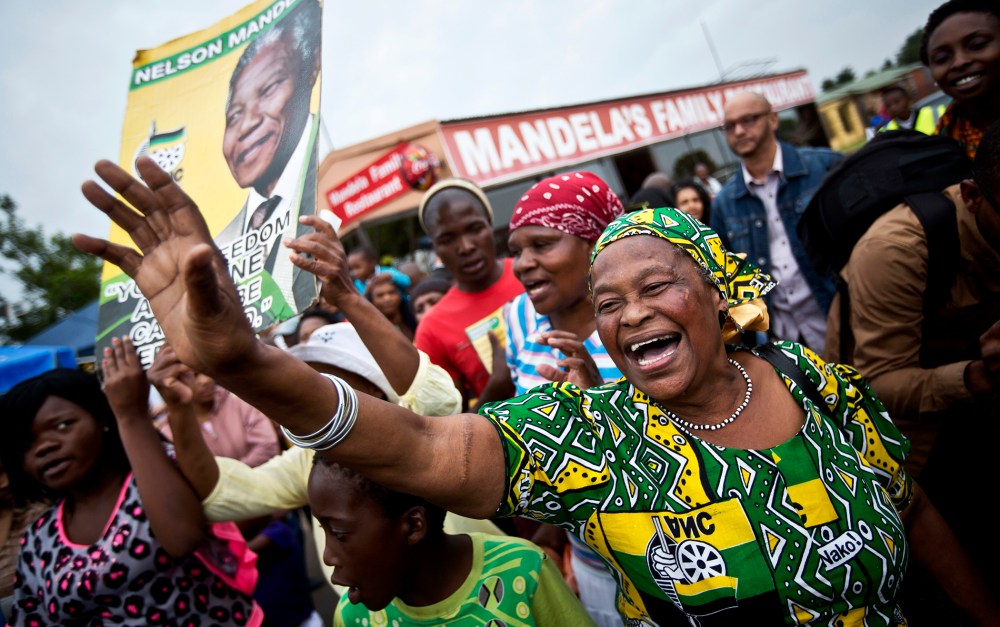 Mourners sing and dance to celebrate the life of Nelson Mandela, in the street outside his old house in Soweto, Johannesburg, South Africa on Dec. 6, 2013.