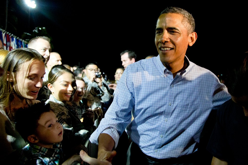 President Barack Obama greets people on the tarmac before boarding Air Force One in Honolulu, Jan. 4, 2014.