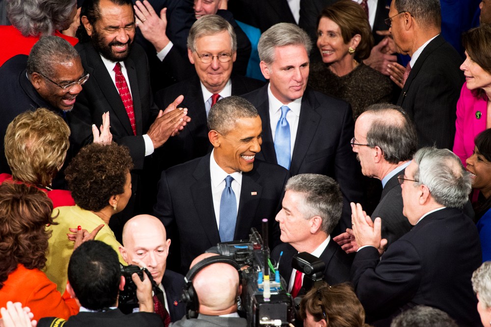 President Barack Obama greets members of Congress as he arrives in the House chamber in the U.S. Capitol to deliver his State of the Union address on Jan. 20, 2015. (Photo By Bill Clark/CQ Roll Call/AP)
