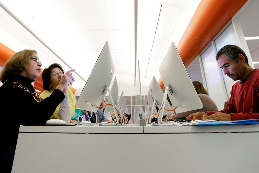 Caroline Ramirez and Sam Martinez use computers at a public library to access the Affordable Health Care Act website, in San Antonio, Texas, Dec. 23, 2013.