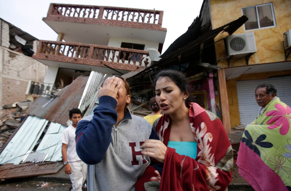 A woman cries as she stands next to house destroyed by the earthquake in the Pacific coastal town of Pedernales, Ecuador, April 17, 2016. (Photo by Dolores Ochoa/AP)