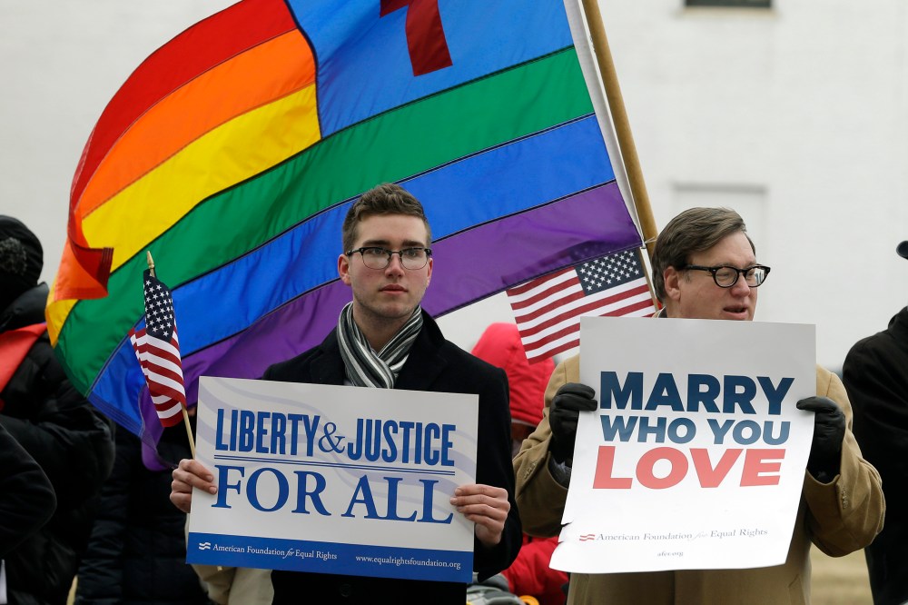Spencer Geiger, left, of Virginia Beach, and Carl Johanson, of Norfolk, hold signs as they demonstrate outside  Federal Court in Norfolk, Va on Feb. 4, 2014.