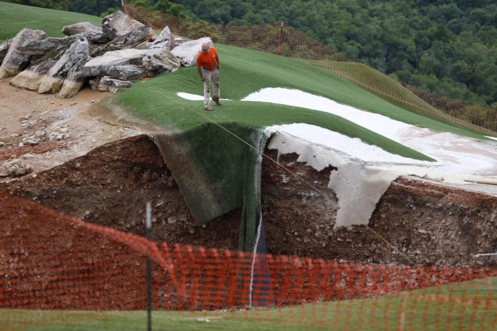 A sinkhole at the Top of the Rock Golf Course in Branson, Mo, May 22, 2015. The 80 feet wide and 35 feet deep hole was created by two separate sinkholes that formed near the entrance to the golf course. (Photo by Nate Papes/Springfield News-Leader/AP)