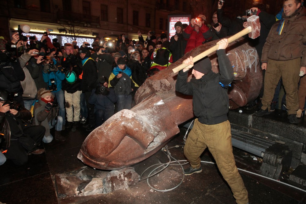 An anti-government protester beats the statue of Vladimir Lenin with a sledgehammer in Kiev, Ukraine on Dec. 8, 2013.