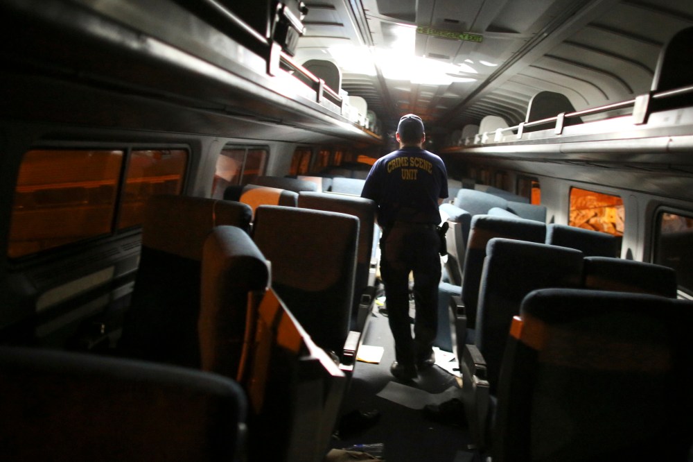 A crime scene investigator looks inside a train car after an Amtrak train wrecked, killing eight people, May 12, 2015, in Philadelphia. (Photo by Joseph Kaczmarek/AP)