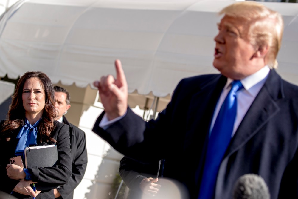 White House press secretary Stephanie Grisham, left, listens as President Donald Trump speaks to reporters on the South Lawn of the White House in Washington, Friday, Nov. 8, 2019.