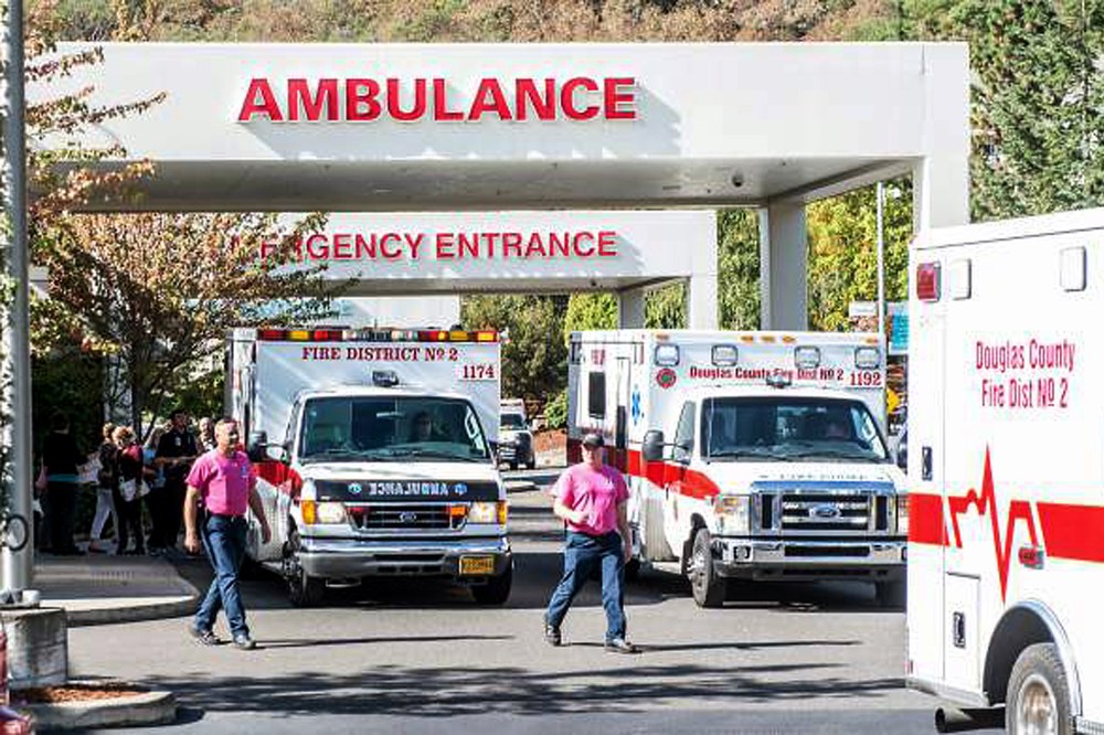 Paramedics return to their ambulances after delivering patients to Mercy Medical Center in Roseburg, Ore., following a deadly shooting at Umpqua Community College, in Roseburg, Oct. 1, 2015. (Photo by Aaron Yost/Roseburg News-Review/AP)