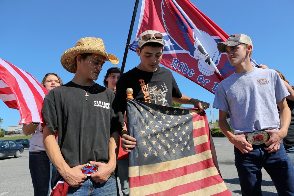 Christiansburg High School students bearing American and Confederate flags gather in a shopping center parking lot after being suspended from school property in Christiansburg, Va. on Sept. 17, 2015. (Photo by Matt Gentry/The Roanoke Times/AP)