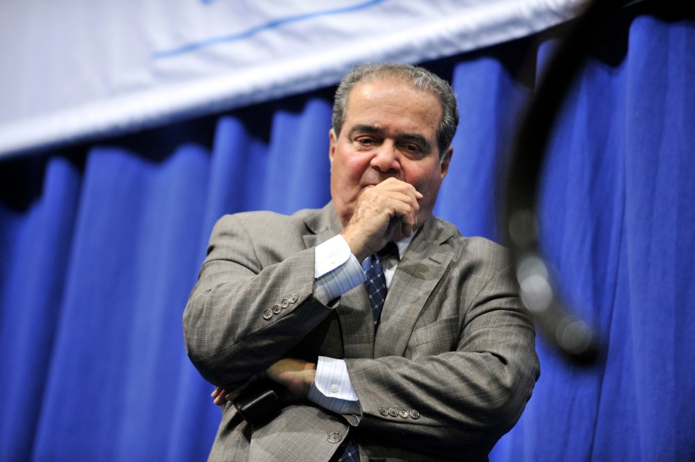 Supreme Court Justice Antonin Scalia stands at the edge of the stage after a question and answer session on Oct. 2, 2013, in Medford, Mass. (Photo by Josh Reynolds/AP)