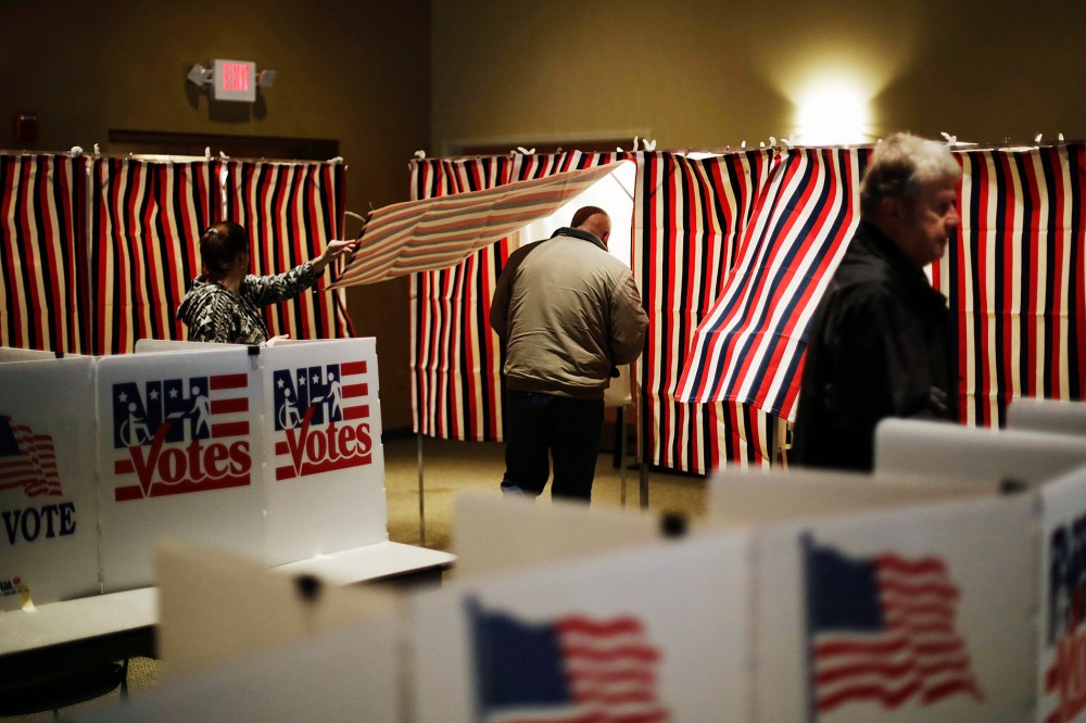 A voter steps into a voting booth to mark his ballot at a polling site for the New Hampshire primary, Feb. 9, 2016, in Nashua, N.H. (Photo by David Goldman/AP)