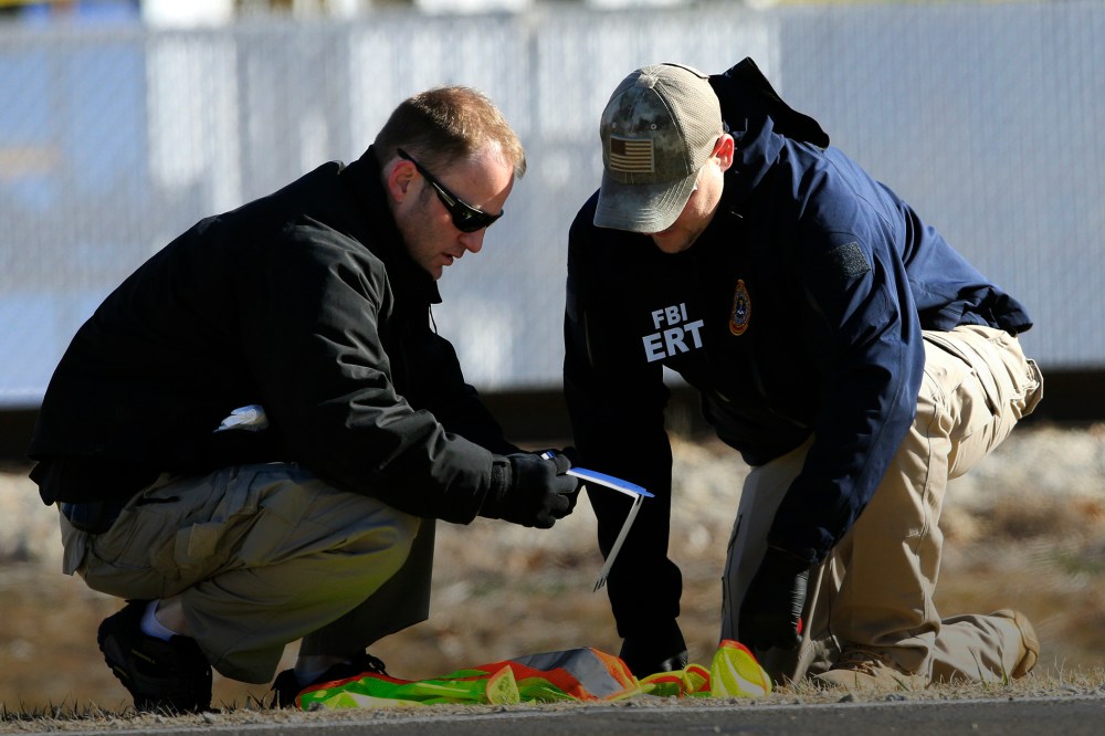 FBI agents look at evidence along Hesston Road outside Excel Industries in Hesston, Kan., Feb. 26, 2016. (Photo by Orlin Wagner/AP)